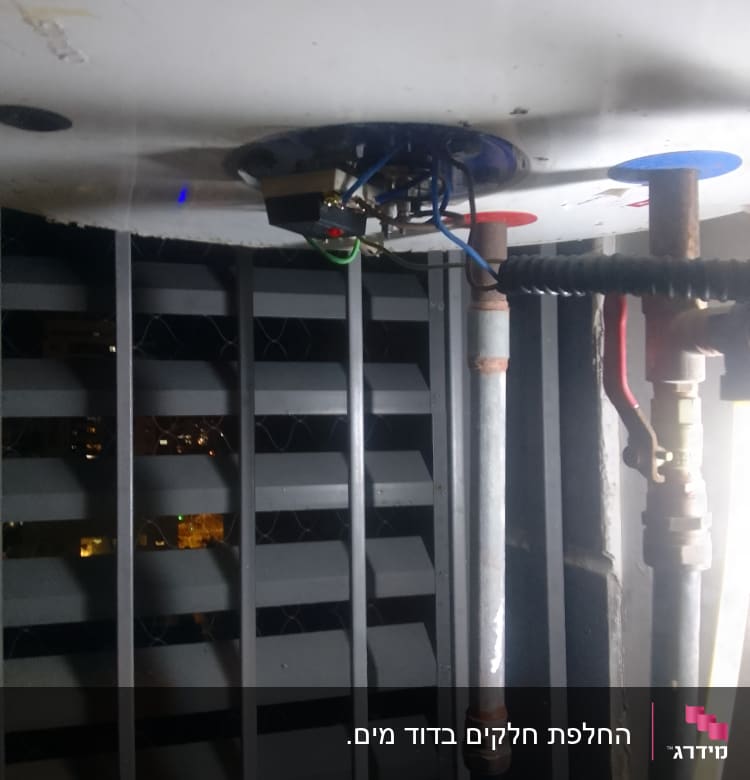 צנרת מתכת עם חיבורים מתחת לדוד מים